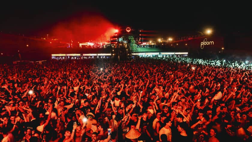 Festival musicale al panorama con pubblico danzante e luci colorate.